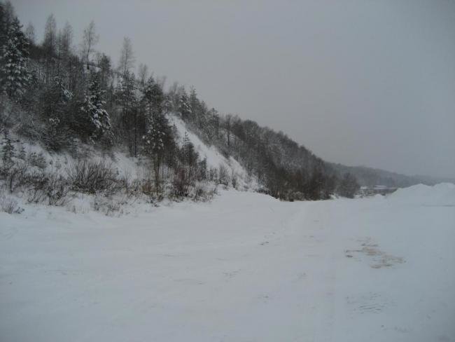 Зимняя дорога вдоль склона